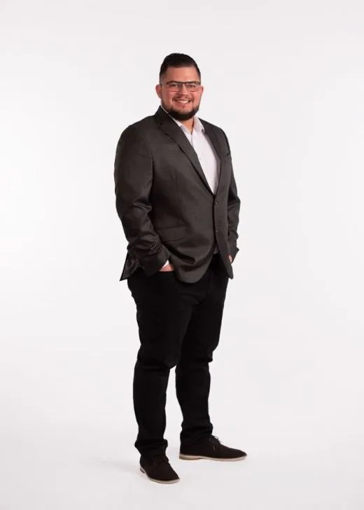 Eduardo Inoa, REALTOR®, standing in a dark suit